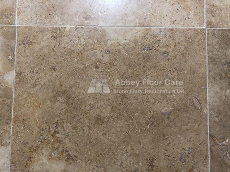 Polished travertine floor in Gloucester with visible holes marked before repair